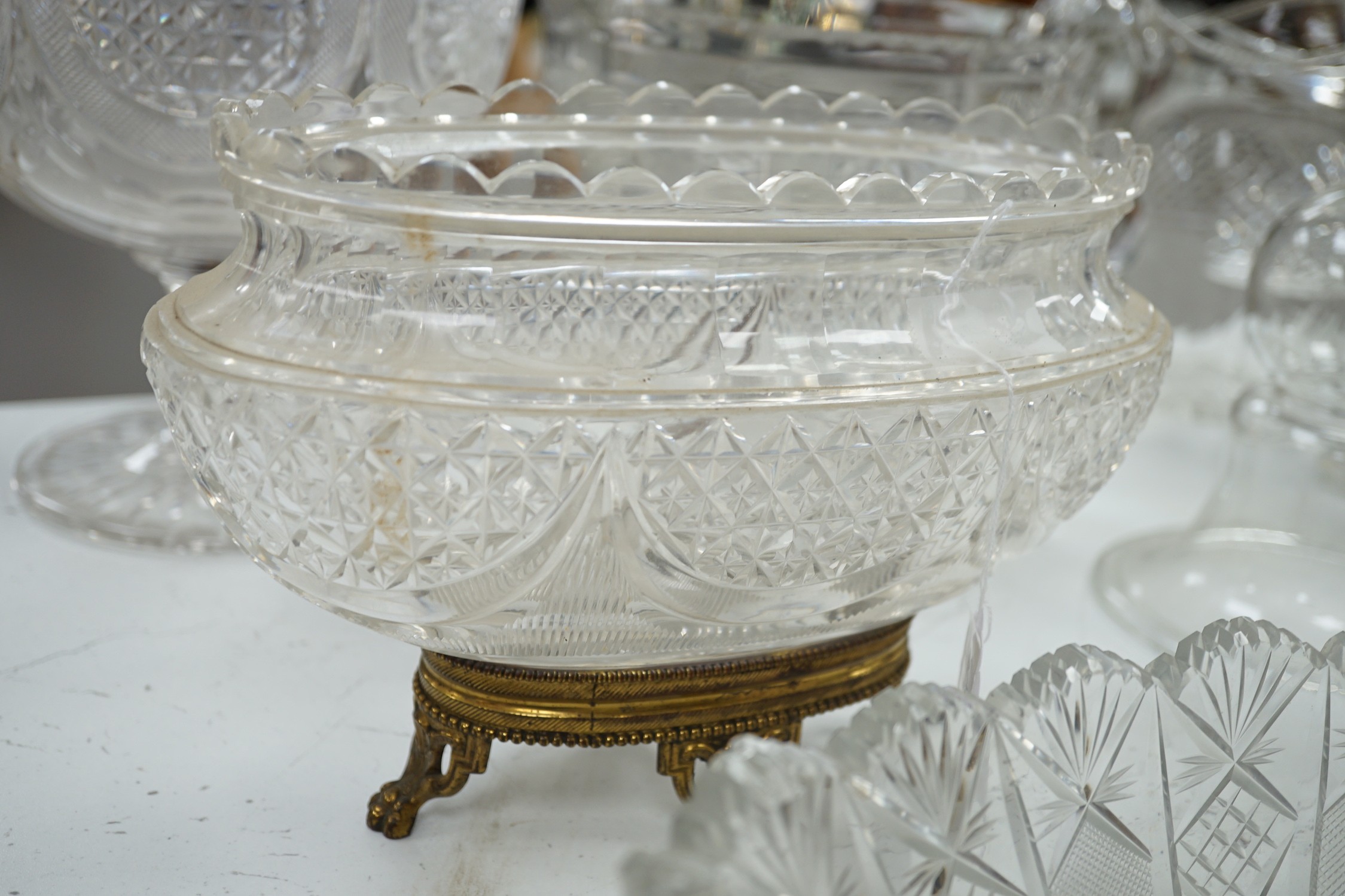 An early 20th century oval cut glass bowl on gilt metal stand, a pair of slice cut decanters and stoppers, a blown glass smoke bell two bowls and four other items of glassware, tallest 26 cm